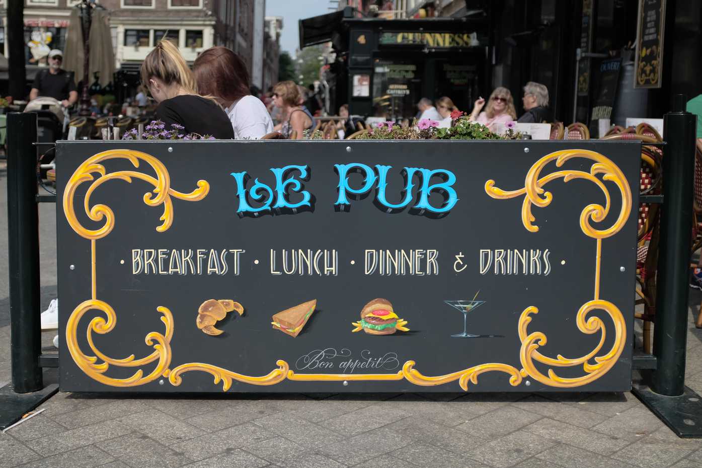 A handpainted sign for a pub with outdoor seating