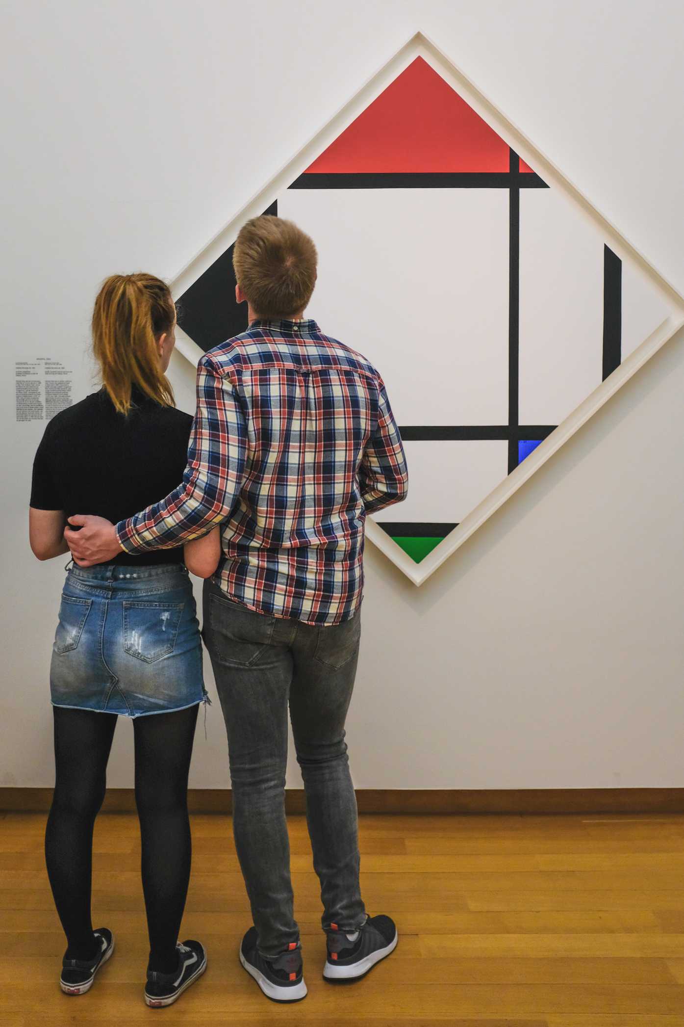 A young couple looks at painting from the art movement De Stijl